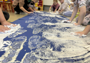 Dzieci tworzą kolejne elementy zimowego krajobrazu.