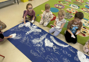 Dzieci tworzą kolejne elementy zimowego krajobrazu.