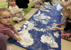 Dzieci tworzą kolejne elementy zimowego krajobrazu.