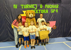 Drużyna Marzeń z naszego przedszkola wraz z nauczycielkami, Misiem Teddy Eddie z Fabryki Języka. Dzieci trzymają w dłoniach puchar, dyplom oraz upominki dla zawodników.