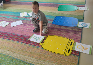 Dzieci umieszczają sylwety bohaterów programu przy właściwym koszu.