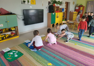 Dzieci umieszczają szablony odpadów przy właściwej planszy kosza.