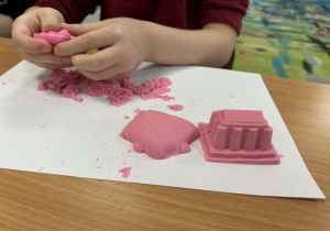 Rzeźby z różowego piasku kinetycznego.