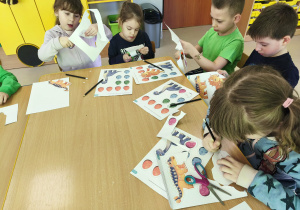 Przy połączonych stołach wycinamy szablony dinozaurów i ich jaj.