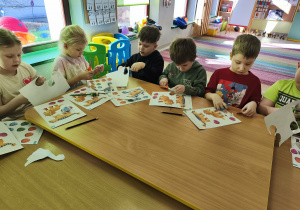 Przy połączonych stołach wycinamy szablony dinozaurów i ich jaj.