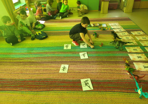 Dzieci biorą udział w zajęciach edukacyjnych w ramach obchodów Dnia Dinozaura.