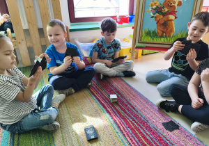 Zespół pod opieką nauczycielki gra w "Piotrusia". Na kartach przedstawione są obrazy znanych malarzy polskich i zagranicznych.