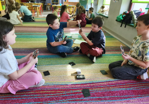 Zespół pod opieką nauczycielki gra w "Piotrusia". Na kartach przedstawione są obrazy znanych malarzy polskich i zagranicznych.