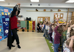 Aktor uczy dzieci wykonywać rycerski ukłon.