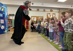 Aktor uczy dzieci wykonywać rycerski ukłon.