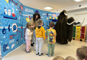 Dzieci witają mamuta na scenie.