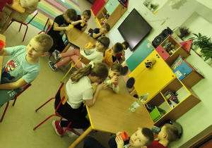 Chętne dzieci częstują się naturalną wodą w swoich, nowych kubkach.