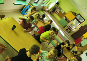 Dzieci piją naturalną wodę w swoich, nowych kubkach.