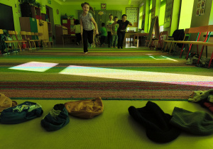 Dzieci rywalizując w zespołach, biorą udział w konkurencji "Bierz czapkę".