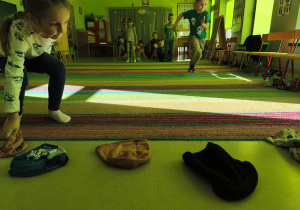 Dzieci rywalizując w zespołach, biorą udział w konkurencji "Bierz czapkę".