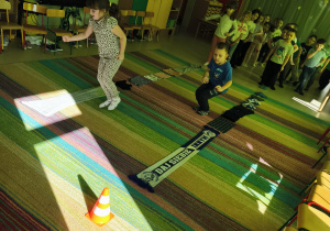 Zawodnicy startują w konkurencji sportowej "Szalikowe skoki".