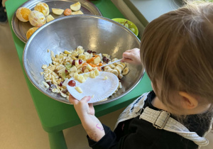 Dzieci wrzucają pokrojone owoce do miski.