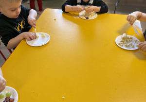 Dzieci kroją owoce.