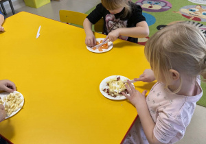 Dzieci kroją owoce.