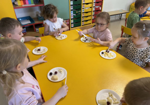 Dzieci kroją owoce.