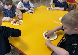 Dzieci kroją owoce.