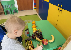 Dzieci układają owocowe kompozycje.