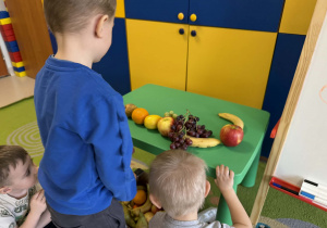 Dzieci układają owocowe kompozycje.
