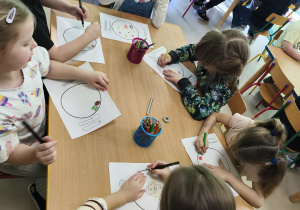 Kilkoro dzieci przy stole rysuje swój, zdrowy posiłek.