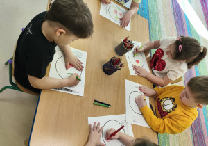 Kilkoro dzieci przy stole rysuje swój, zdrowy posiłek.