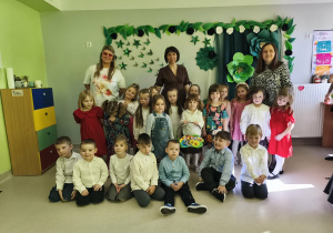 Dzieci z grupy "Żabek" wraz z paniami na tle tematycznej dekoracji.