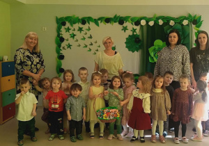 Dzieci z grupy "Jeżyków" wraz z paniami na tle tematycznej dekoracji.