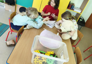 Dziewczynki podczas zabawy swobodnej przy stole.