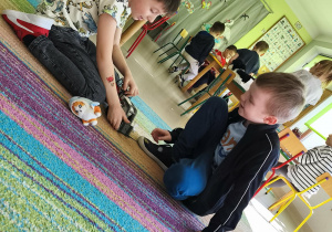 Chłopcy bawią się zabawkowym pojazdem.