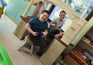 Chłopcy bawią się razem w kąciku kuchennym.