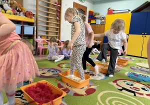 Dzieci po kolei pokonują ścieżkę sensoryczną.