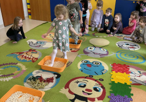 Dzieci po kolei pokonują ścieżkę sensoryczną.