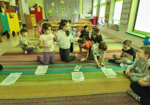 Wybrane dzieci młodsze układają obrazki produktów spożywczych przy właściwej ilustracji.