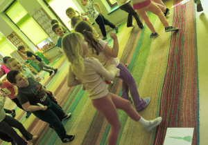 Dzieci biorą udział w zabawie ruchowej "Grządki".