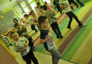 Dzieci biorą udział w zabawie ruchowej "Grządki".