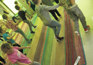 Dzieci biorą udział w zabawie ruchowej "Grządki".