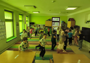 Dzieci biorą udział w zabawie ruchowej "Grządki".