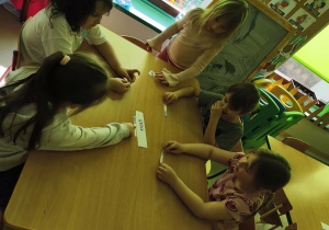 Dzieci, które mają podpis owocu/warzywa wskazanego przez nauczycielkę ustawiają się przy właściwym napisie.