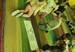 Wybrane dzieci układają historyjkę obrazkową w odpowiedniej kolejności, a pozostałe przedszkolaki sprawdzają poprawność.