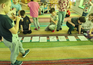 Wybrane dzieci starsze umieszczają podpisy do każdego obrazka, tworzącego historię powstawania chleba.