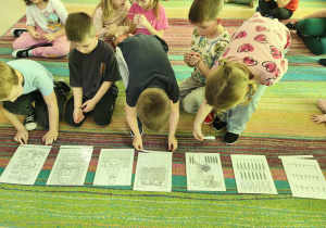 Wybrane dzieci starsze umieszczają podpisy do każdego obrazka, tworzącego historię powstawania chleba.