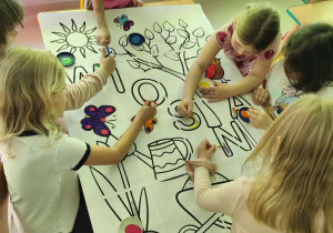 Starsze dziewczynki malują elementy wybranymi przez siebie farbami.