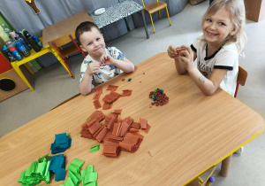 Młodsi chłopcy wraz ze starszymi koleżankami wypełniają elementy przygotowanymi kuleczkami z bibuły.