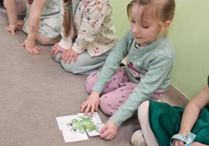 Dzieci z grupy "Żabek" układają wiosenne puzzle.
