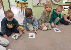 Dzieci z grupy "Żabek" układają wiosenne puzzle.