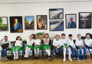 Dzieci siedząc na krzesełkach, oczekują na swój występ.